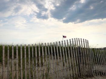 Wooden fence on field against sky