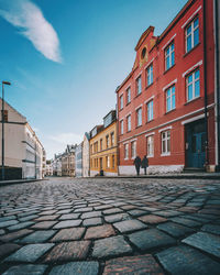 Footpath amidst buildings against sky