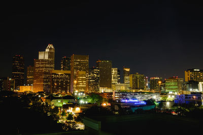 Illuminated cityscape against sky at night