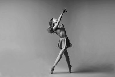 Ballet dancing against gray background