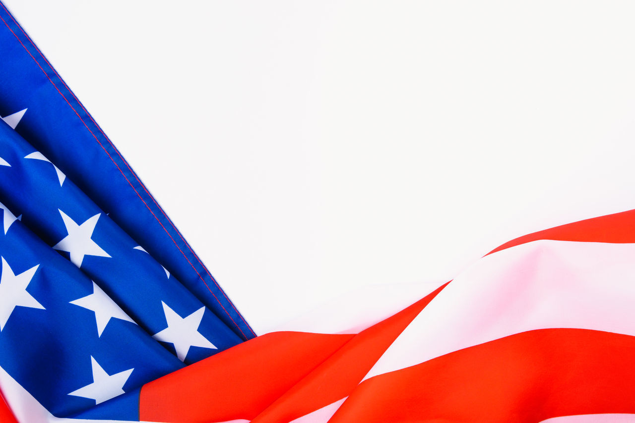 CLOSE-UP OF FLAG AGAINST BLUE SKY