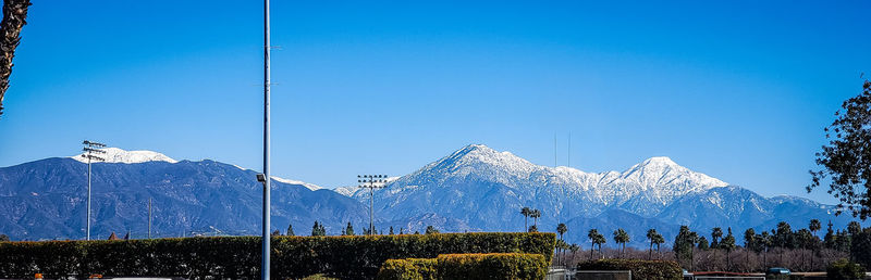 Scenic view of snowcapped mountains against clear blue sky