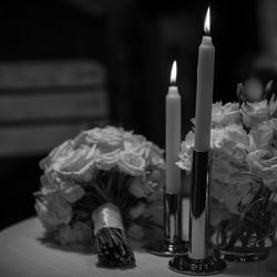 Close-up of candles and flowers on table