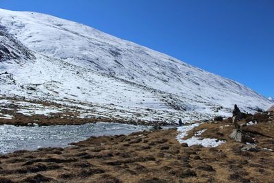 Scenic view of snowcapped mountains against clear blue sky