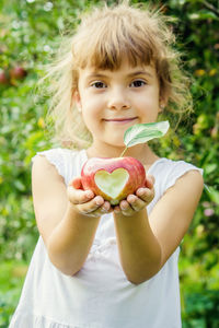 Portrait of cute girl holding apple