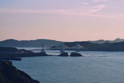 Sailboats in sea against sky during sunset