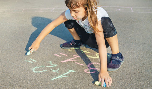 Cute girl writing on road