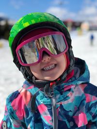 Portrait of cute girl wearing ski goggles outdoors