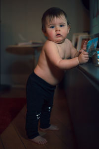 Portrait of shirtless boy standing at home