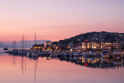 Sailboats moored in sea against clear sky during sunset