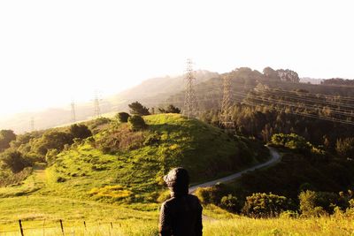 Rear view of man looking at mountain against sky