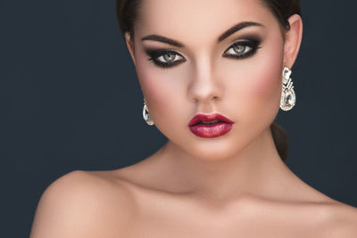 Close-up of young woman against black background