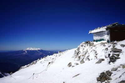 Scenic view of snowcapped mountains against clear blue sky