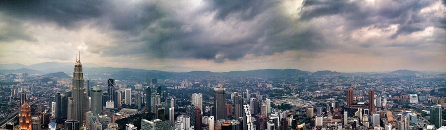Panoramic view of cityscape against cloudy sky