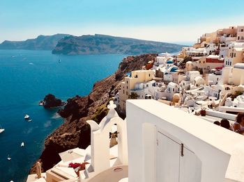 High angle view of townscape by sea against sky