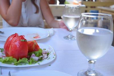 Midsection of woman having food at table in restaurant