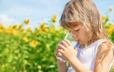 Girl drinking water on field