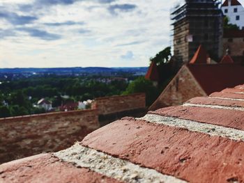 Close-up of stone wall by building against sky