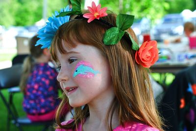 Close-up of cute girl with face paint looking away