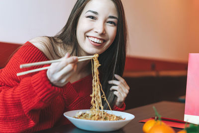 Portrait of a smiling young woman holding food