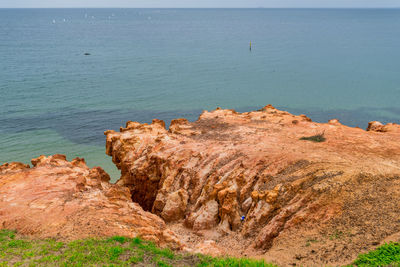 Rock formation on beach against sky