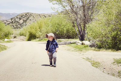 Boy wearing sunhat walking on footpath