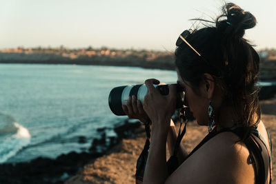 Female photographer in the desert taking photos at golden hour.