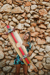 Young happy female with skateboard and sunglasses