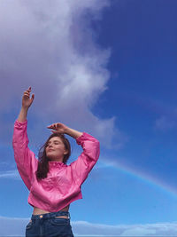 Low angle view of woman standing against pink sky