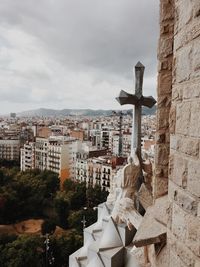 Buildings in city against cloudy sky