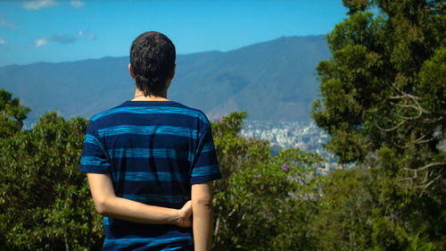 Rear view of man standing against mountains