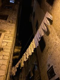 Low angle view of clothes hanging on wall in city