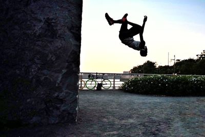 Silhouette man jumping against sky