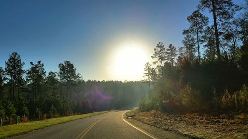 Empty road with trees in background