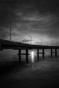 Bridge over sea against sky during sunset