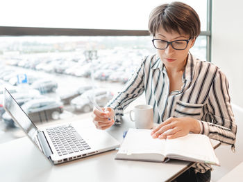 Business woman works with laptop, organiser in co-working center. workplace for freelancers.