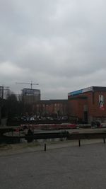 Buildings in city against cloudy sky