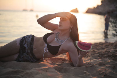 Beautiful youg woman witha watermelon in a beach