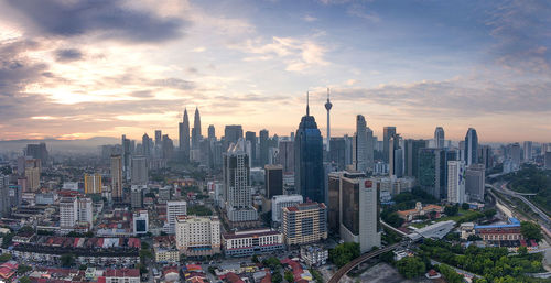 Aerial view of buildings in city against sky during sunset