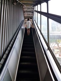 Rear view of people walking on steps