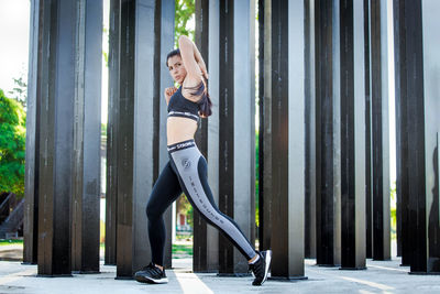 Young woman smiling while standing against the wall