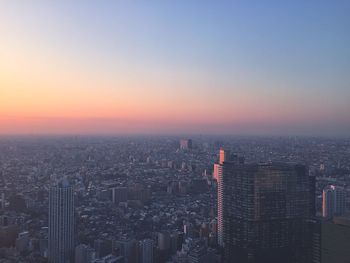 Aerial view of cityscape against sky during sunset