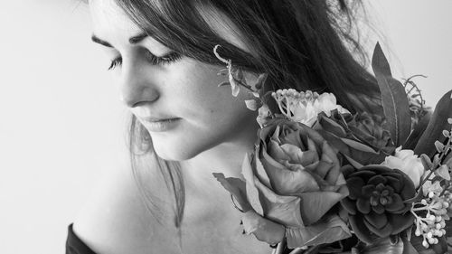 Close-up portrait of woman with red flower