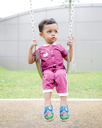 Close-up of boy on swing at playground