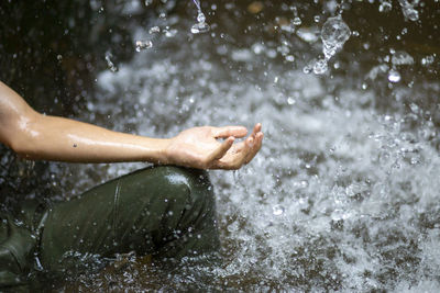 Low section of man splashing water in rain