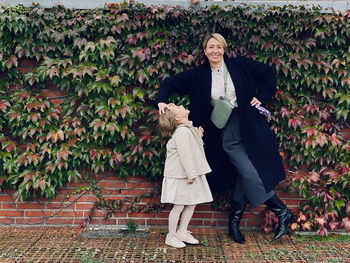 Full length of man with woman standing against plants