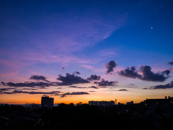 Silhouette buildings against sky during sunset