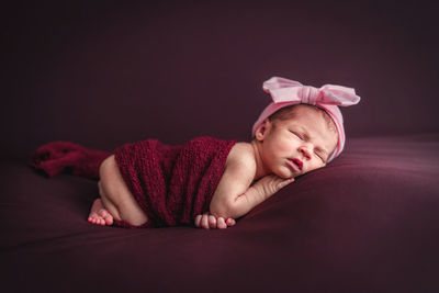 A newborn baby girl with a headband sleeping peacefully. newborn session concept