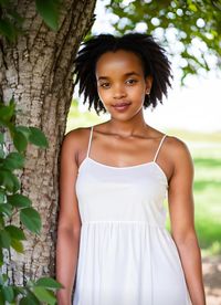 Young woman standing against plants