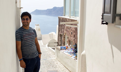 Portrait of young man standing against built structure